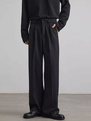 Black pleated wide-leg trousers with a relaxed fit and side pockets.