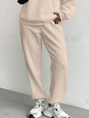 Tan cable knit lounge pants with textured detail, cuffed ankles.
