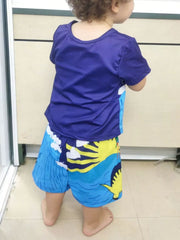 Toddler blue crew neck t-shirt with dinosaur print shorts.