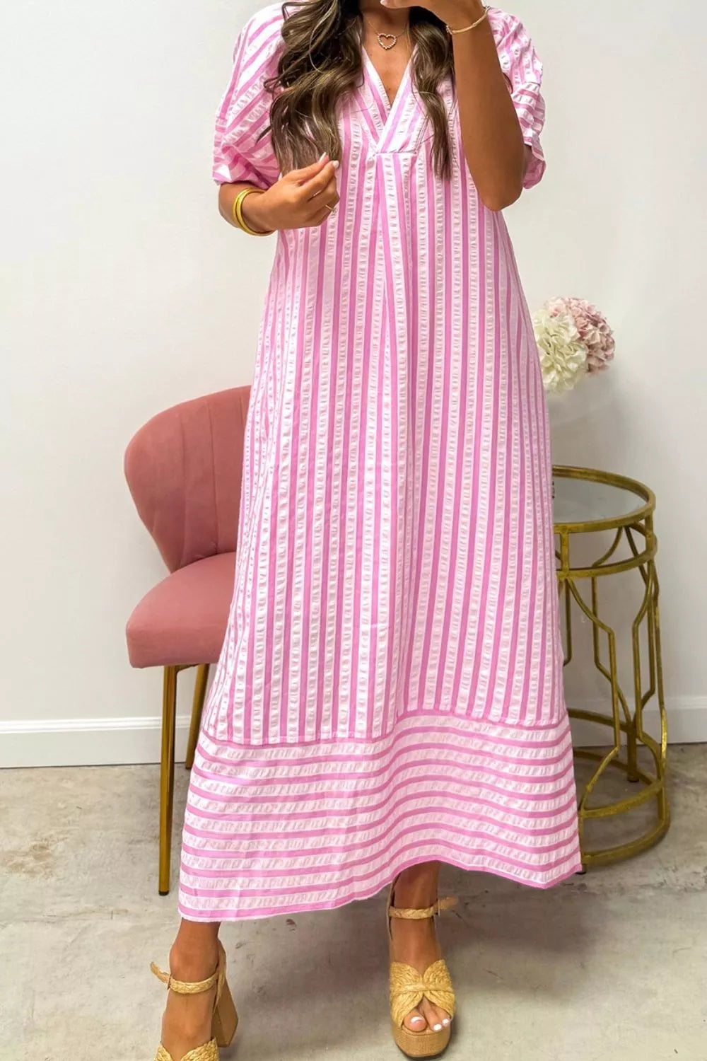 Pink striped midi dress with V-neck and short puff sleeves.