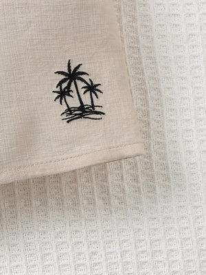 Two-piece kids' set in beige linen-look fabric with black embroidered palm trees.