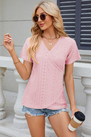 Blush pink eyelet wrap V-neck top with short sleeves and a casual fit.