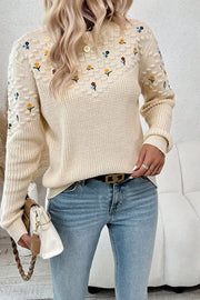 Beige embroidered round-neck sweater with dropped shoulders and a checkered pattern detail.