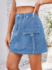 Denim cargo skirt in dusty blue with elastic waistband and utility pocket detail.