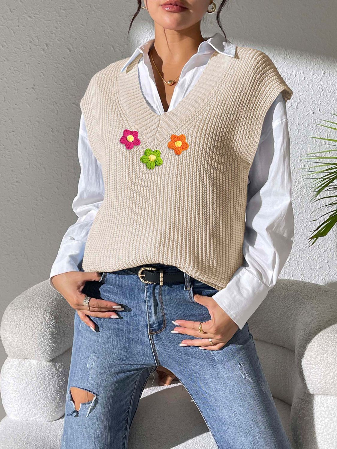 Beige ribbed knit vest with embroidered flowers in pink, green, and orange.