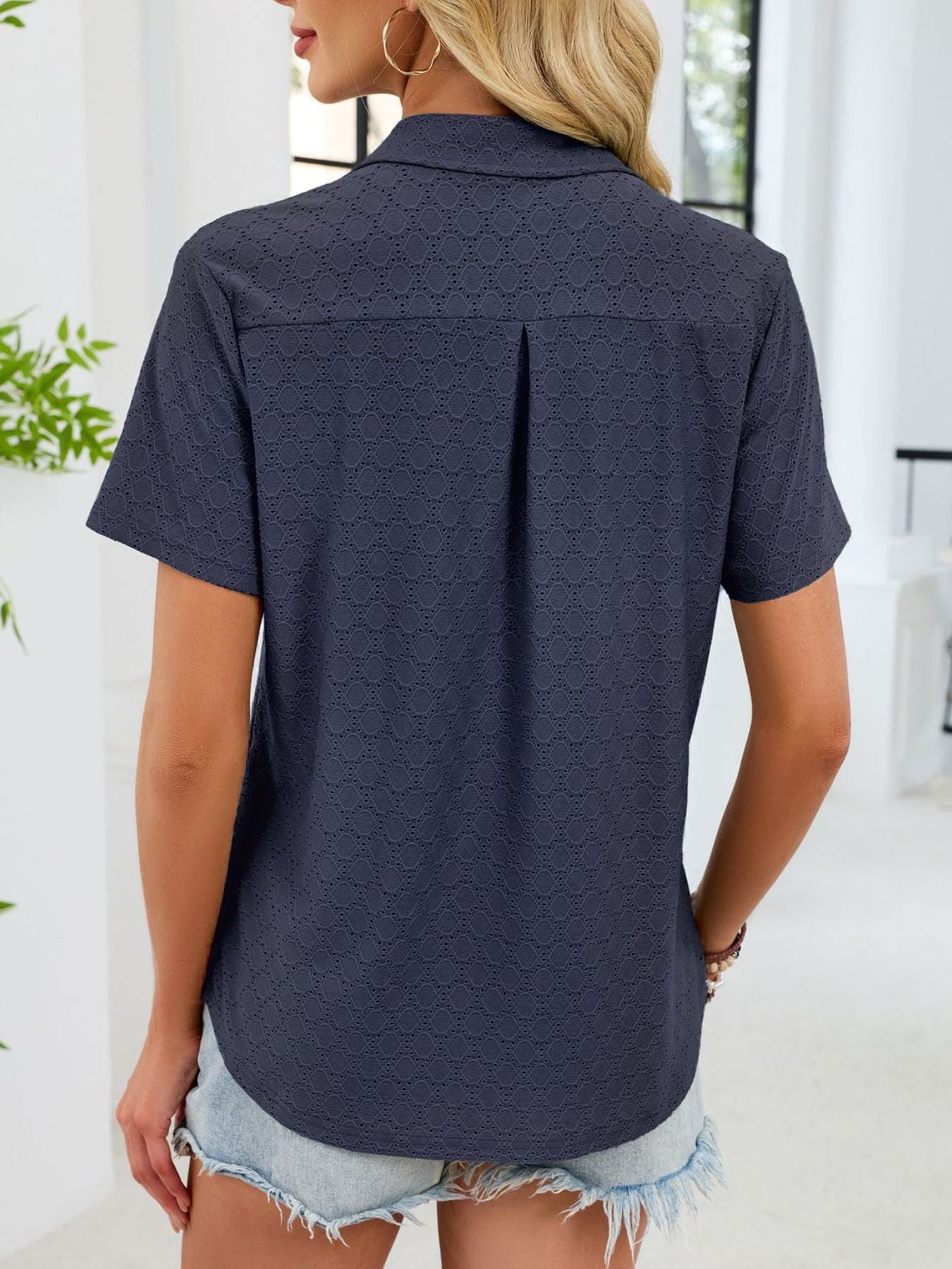 Indigo eyelet polo collar blouse with short sleeves and a back pleat detail.