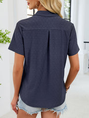 Indigo eyelet polo collar blouse with short sleeves and a back pleat detail.