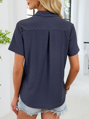 Indigo eyelet polo collar blouse with short sleeves and a back pleat detail.