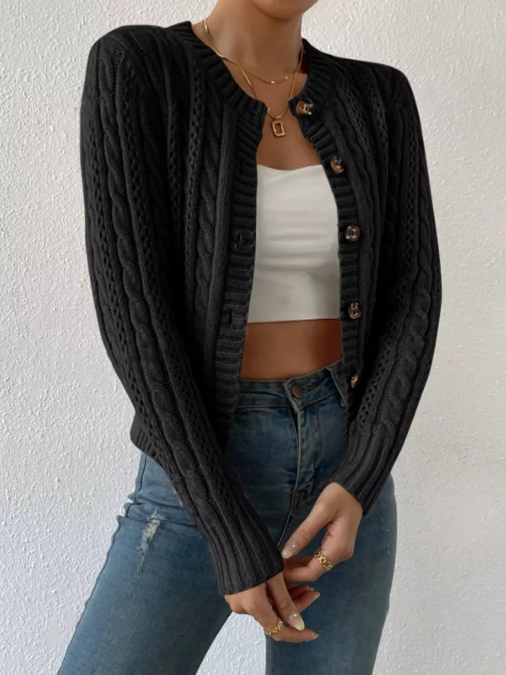 Black cable-knit button-front cardigan with crew neck and long sleeves.