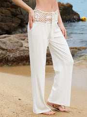 Cream crochet cutout wide leg pants with drawstring waist and tassel detail.
