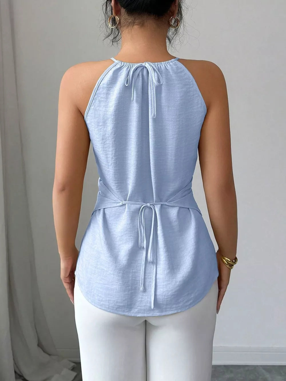 Light blue polyester cami with gathered neck and crisscross wrap detail.