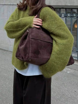 Cozy knit top in Moss with relaxed fit and wide sleeves, styled with a white tee.