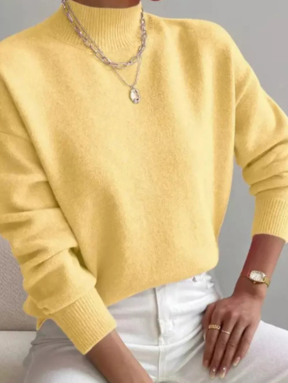 Light yellow mock neck knit sweater with dropped shoulders and ribbed cuffs.