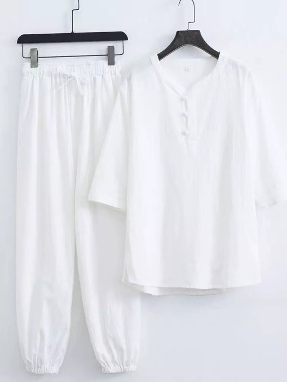 White relaxed fit Chinese-inspired men's pants set with drawstring waist and button-up top.