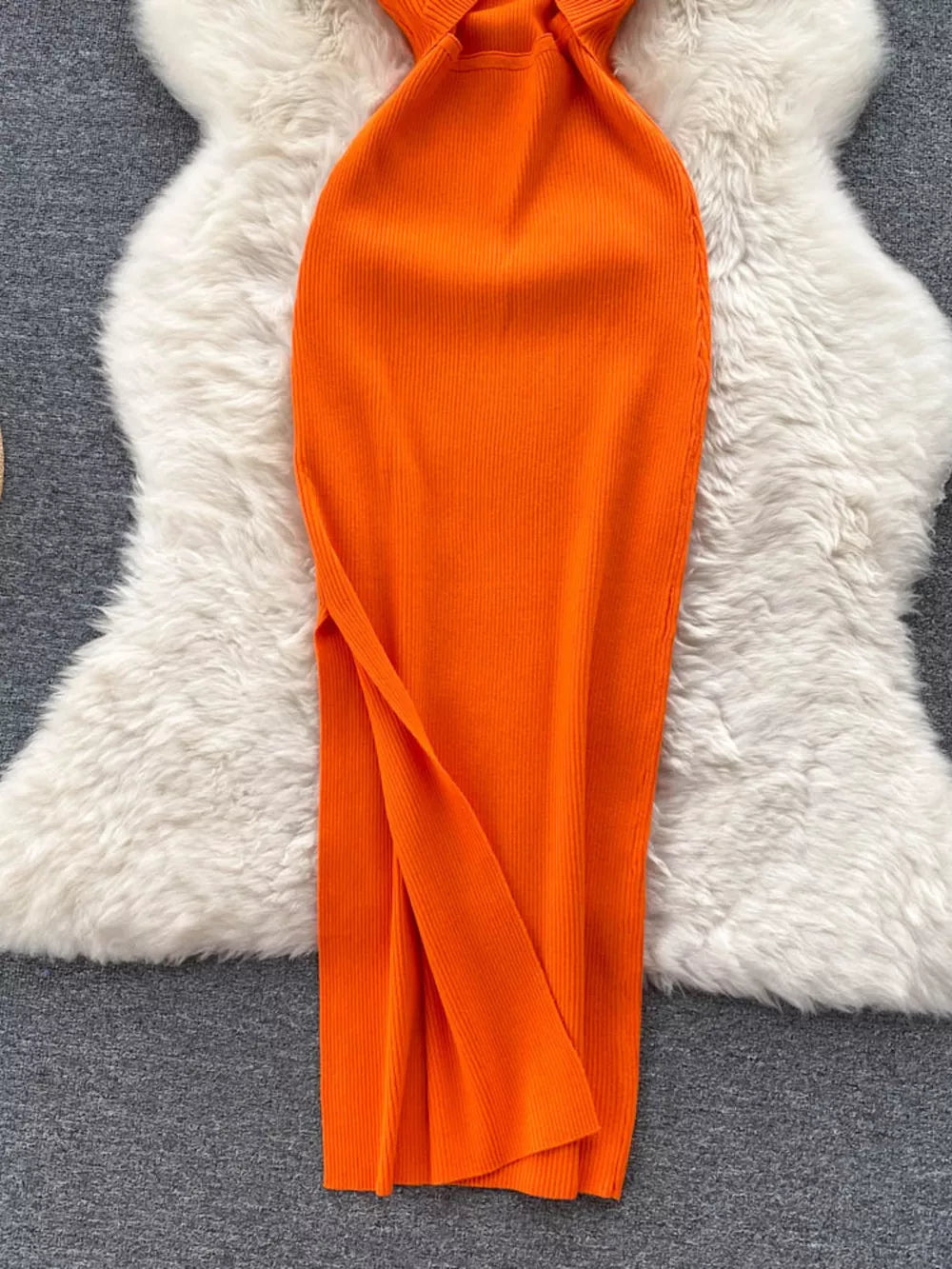 Orange ribbed knit midi dress with cutout back detail and side slit.