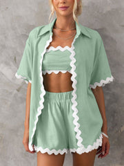 Scalloped edge linen shirt set in gum leaf green with white trim, featuring a button-down shirt, crop top, and shorts.