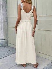 Beige lace-trimmed V-neck maxi dress with a belted waist and spaghetti straps.
