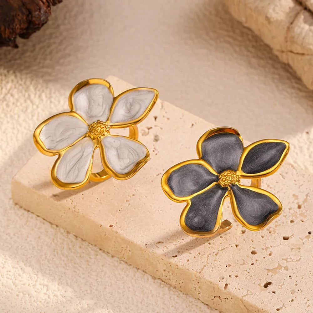 Lustrous floral open rings in cream and dark gray with gold trim.
