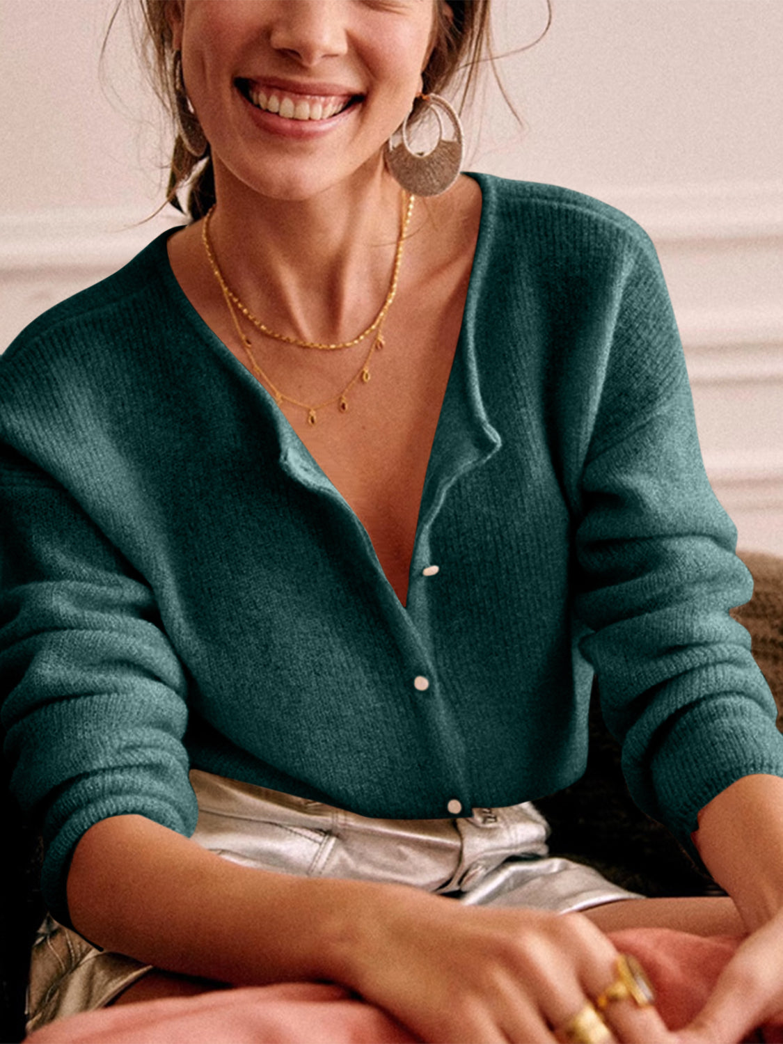 Turquoise cashmere buttoned cardigan with plunging neckline and ribbed texture.