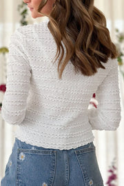 White textured long sleeve top with ruffle trim and smocked detail