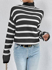 Oversized black and white striped turtleneck sweater with ribbed cuffs.