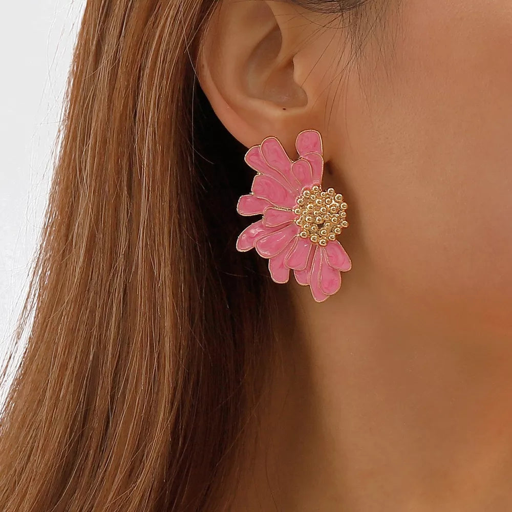 Pink textured flower stud earrings with gold center detail.