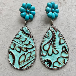 Teardrop earrings with tooled leather, turquoise stones, and silver trim.