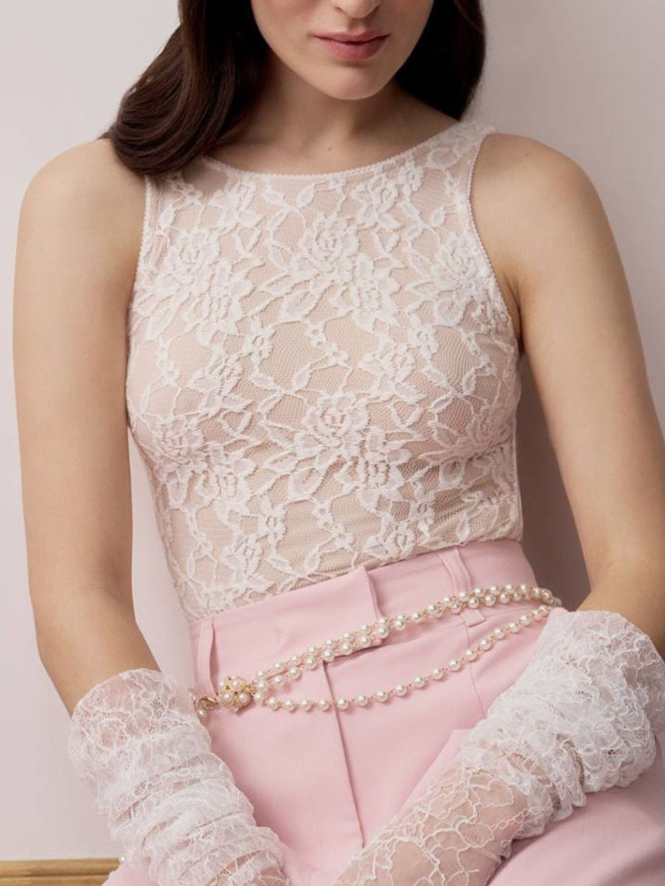 Sheer lace tank top in white with floral pattern and round neckline.