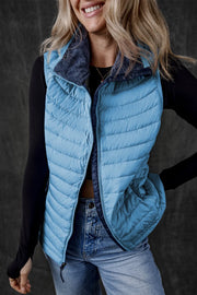 Pastel blue quilted puffer vest with navy fleece collar and zipper detail