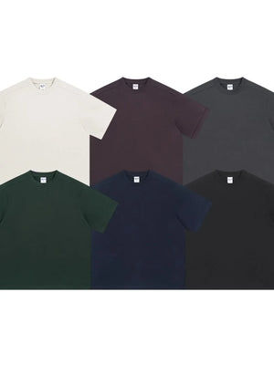 Boxy cut t-shirts in white, dark green, navy, mauve, dark gray, and black.