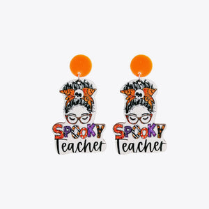 Acrylic teacher earrings with spooky skull and glasses design, orange top.