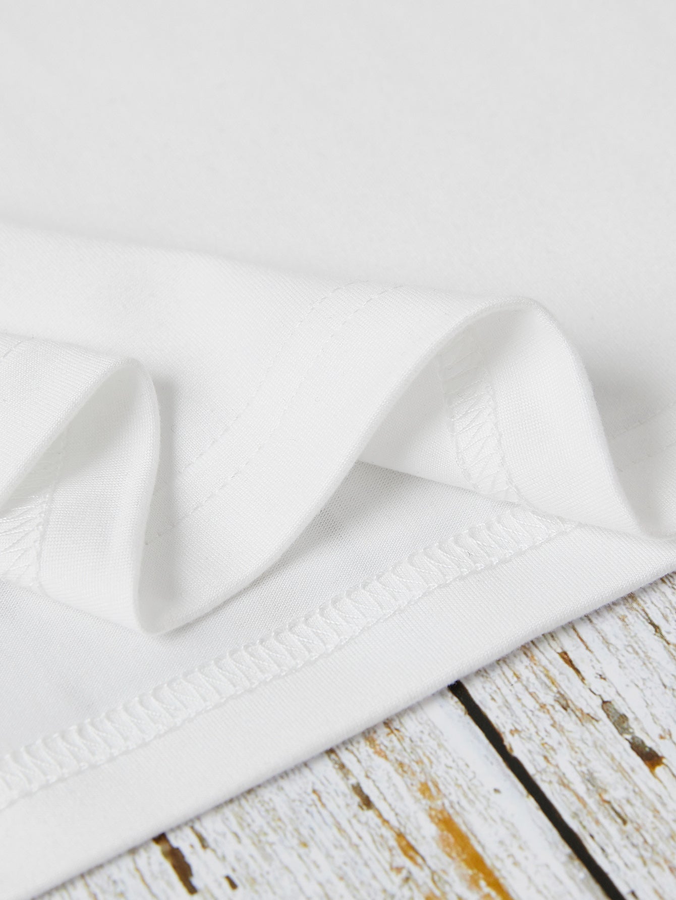 White crewneck t-shirt showing fabric texture and stitching detail.