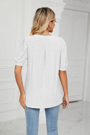 White perforated puff sleeve blouse with eyelet detail and pintuck back.
