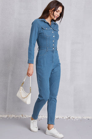 Denim utility jumpsuit in medium wash with defined waist, button front, and chest pockets.