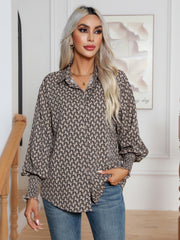 Camel geometric print blouson sleeve shirt with button front and smocked cuffs.
