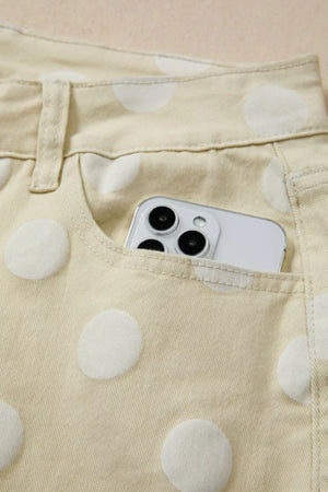 Polka dot high-waisted wide-leg jeans in beige denim with a phone in the pocket.