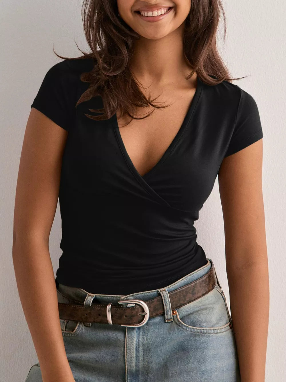 Black crossover ruched fitted t-shirt with a deep V-neck and short sleeves.