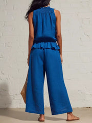 Blue smocked peplum top and flowing wide-leg pants set with ruffled hem detail.