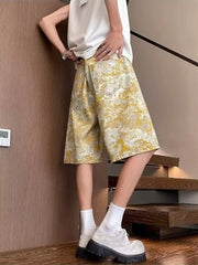 Floral print wide-leg denim shorts in yellow and white, made of 100% cotton.