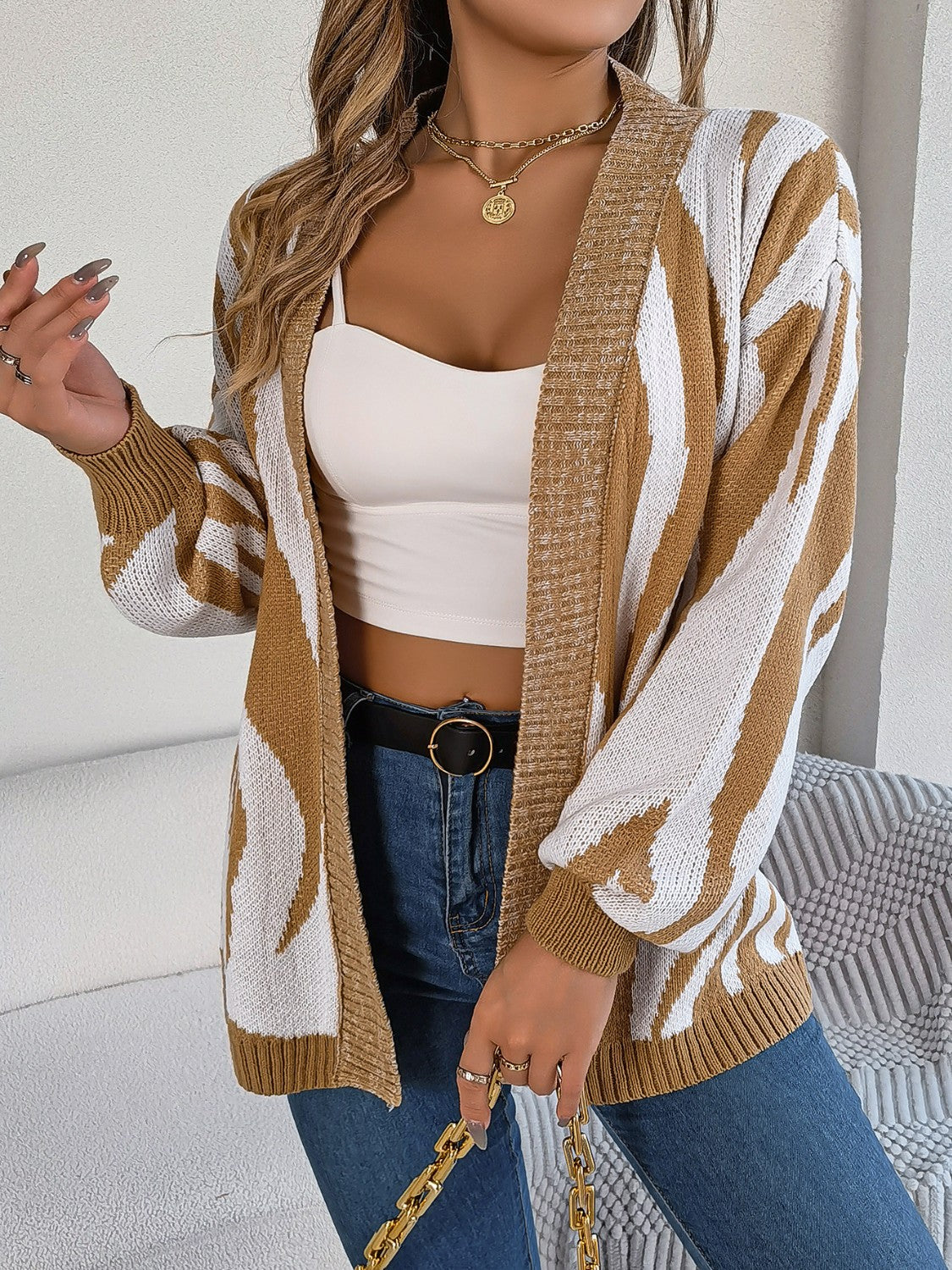 Caramel and white zebra stripe open-front knit cardigan with balloon sleeves.