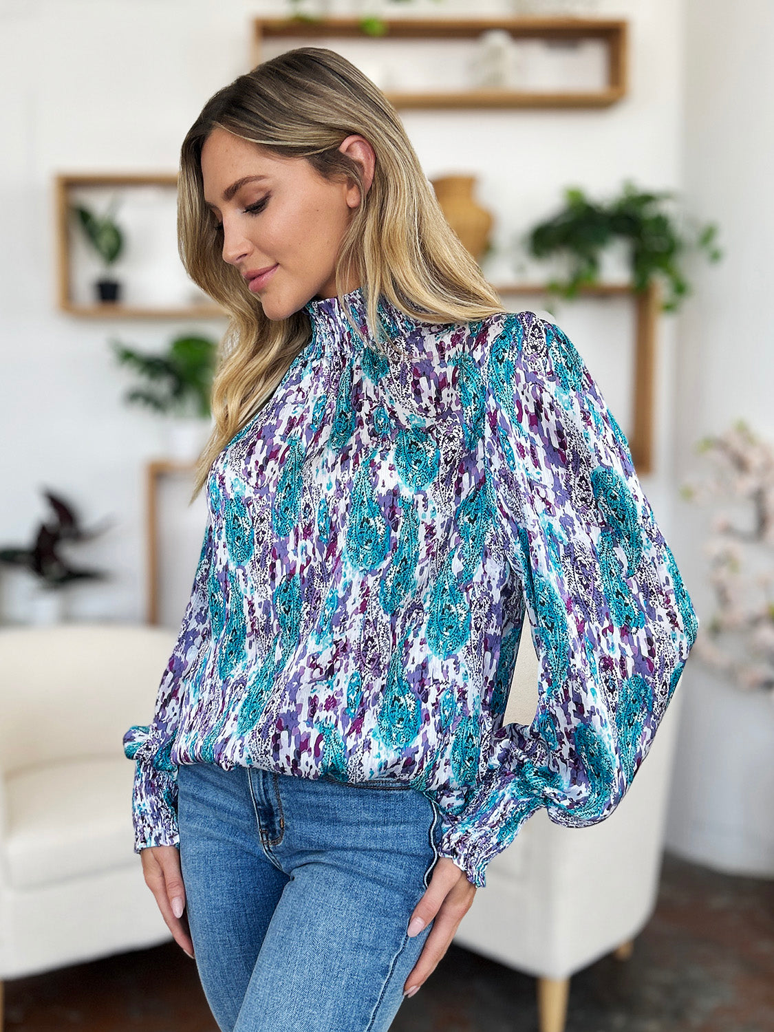 High neck abstract print blouse in blue and red-violet with long sleeves and smocked cuffs.