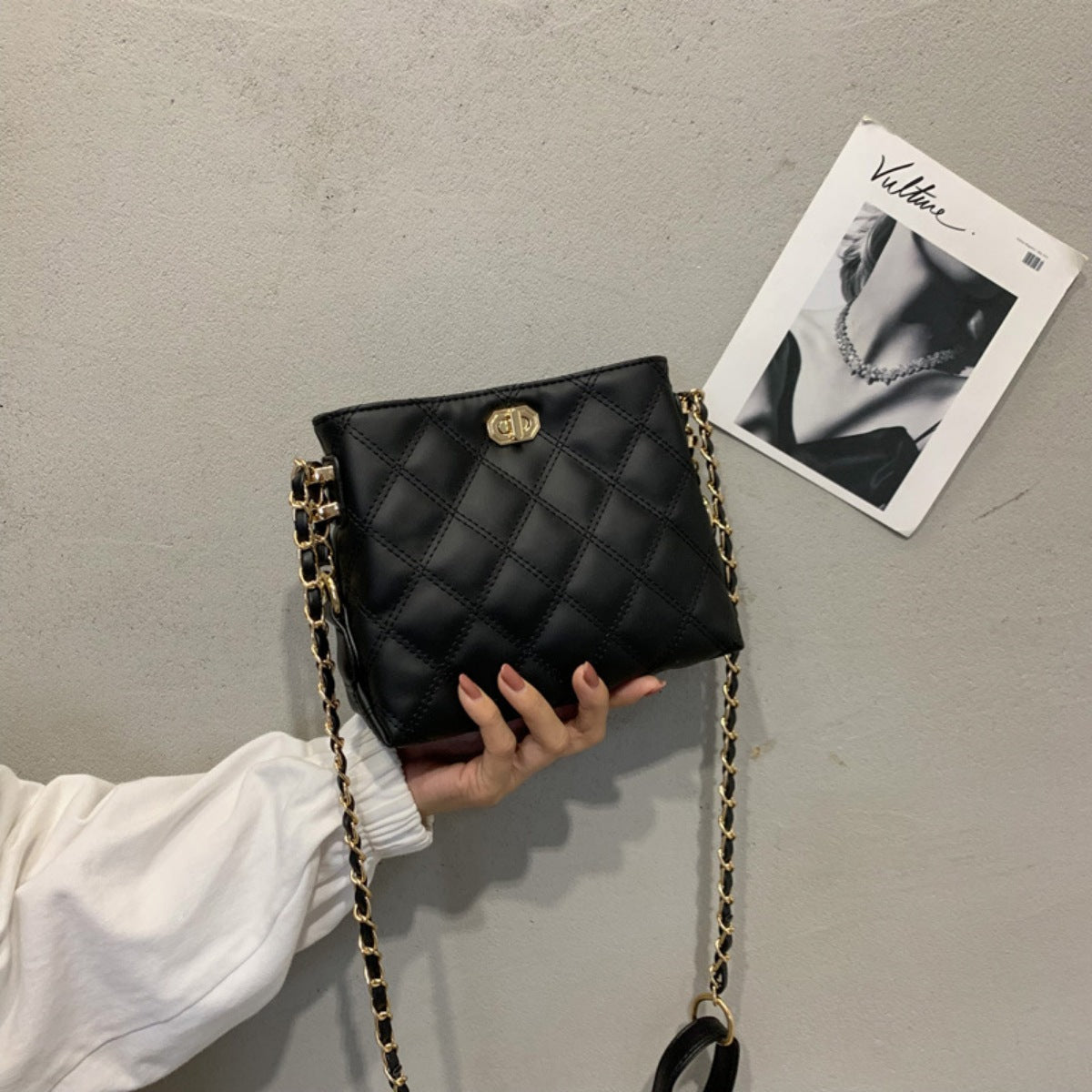 Black quilted crossbody bag with diamond pattern and gold chain strap