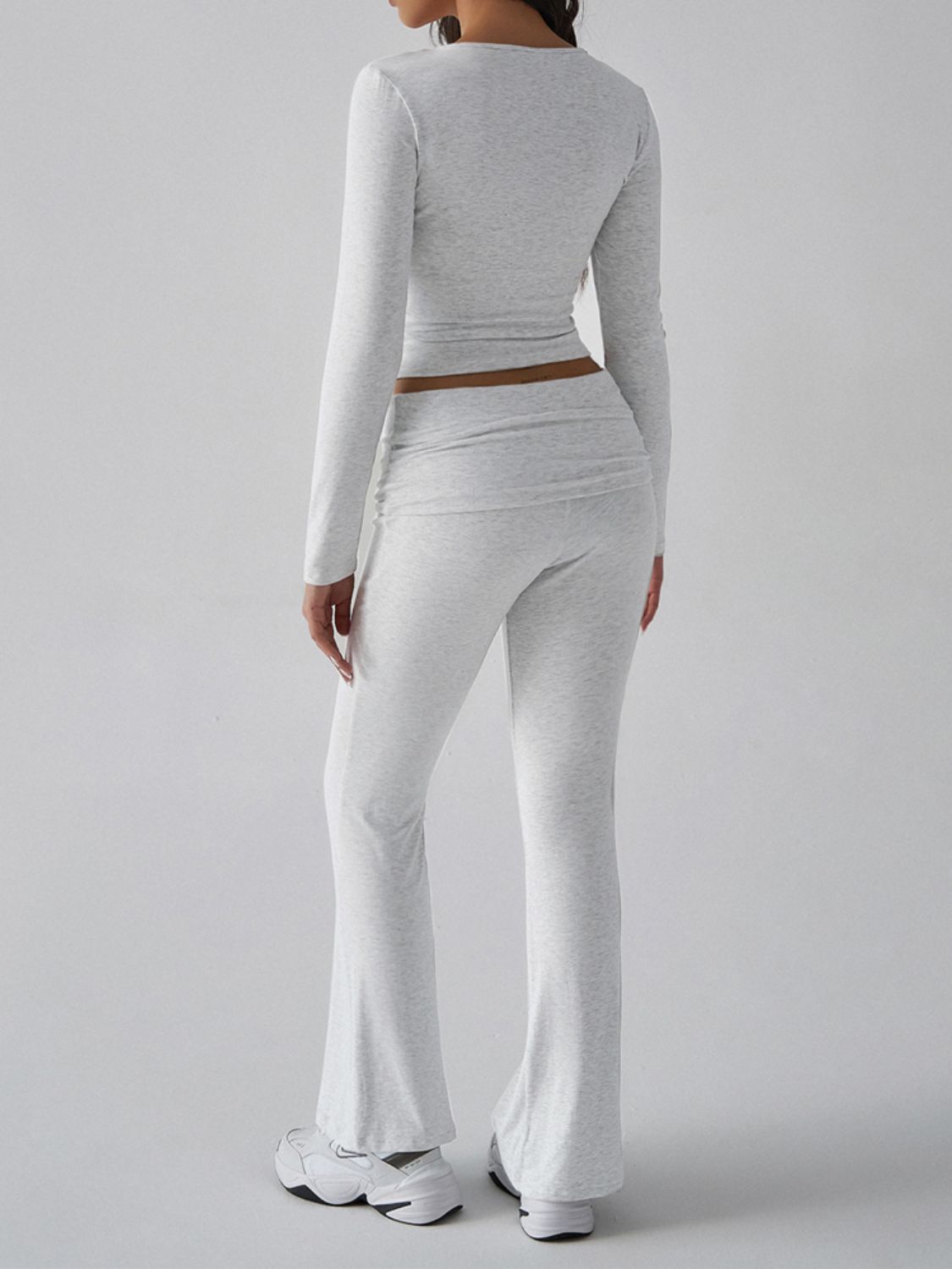 Light gray long sleeve cropped top and flared lounge pants with ruched detail.