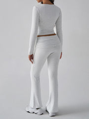 Light gray long sleeve cropped top and flared lounge pants with ruched detail.