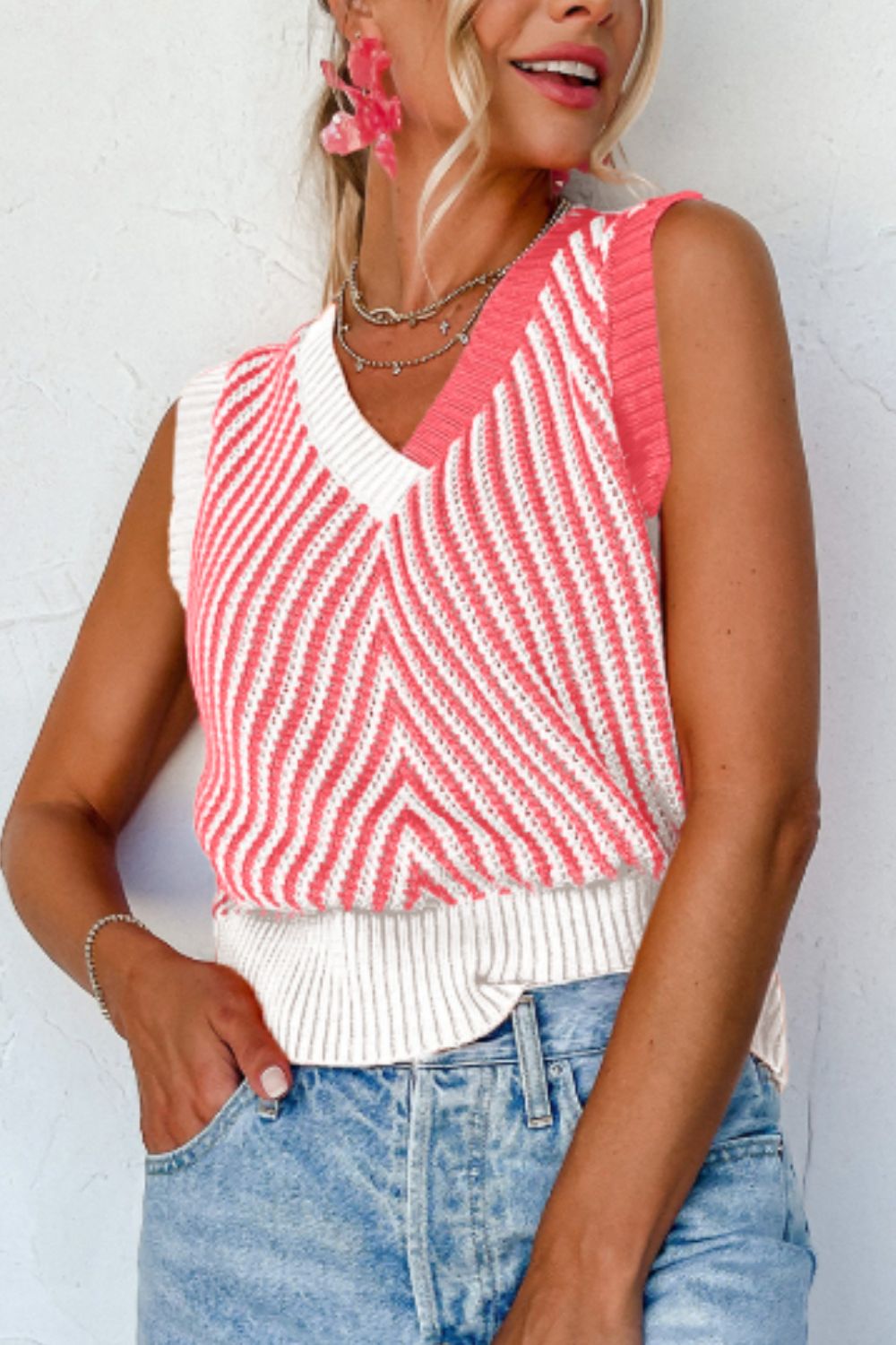 Chevron knit vest with v-neck and colorblock coral and white stripes.