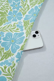 Mini dress with blue floral print and green leaves, showing a phone in the pocket.