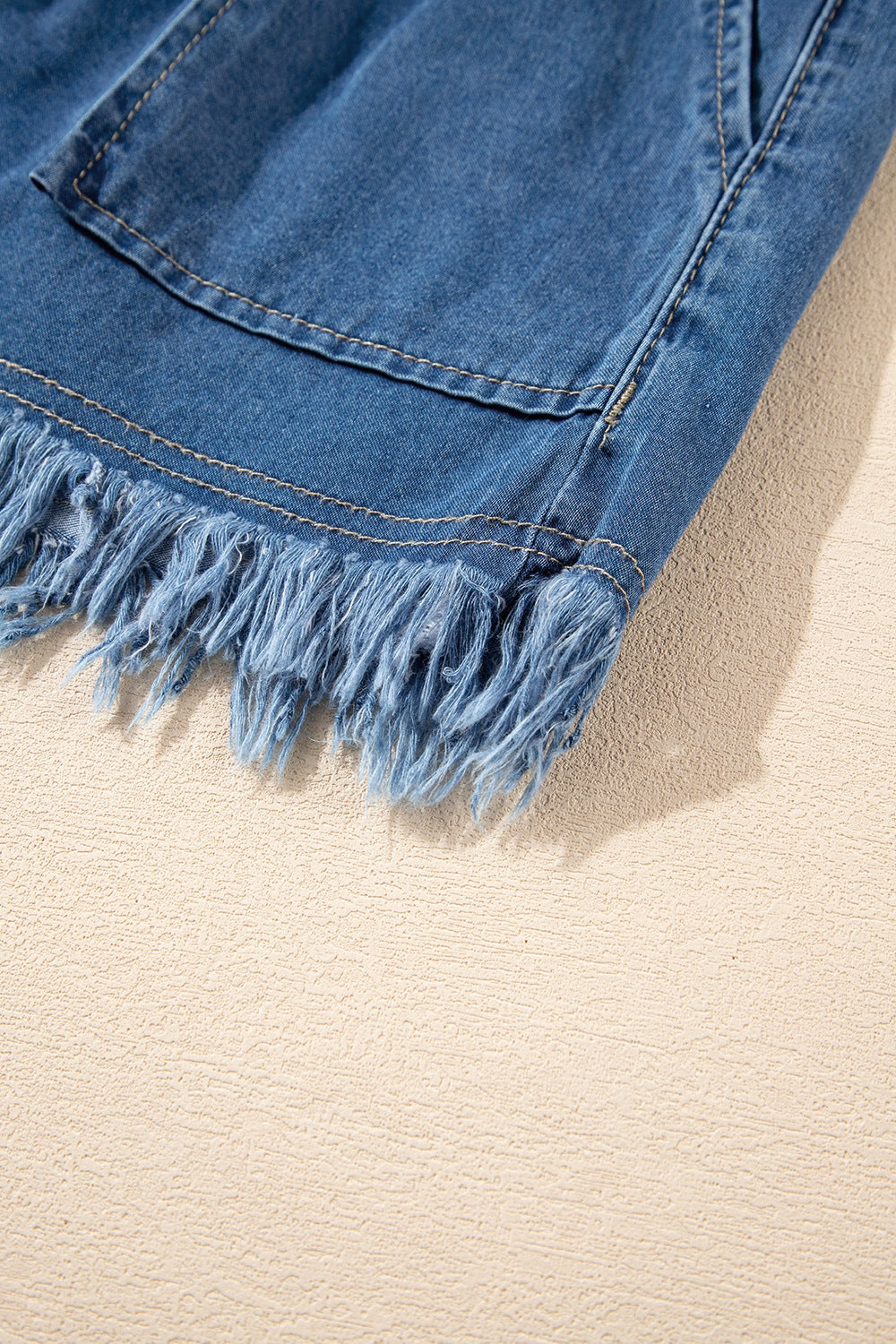 Denim drawstring shorts in navy with frayed hem detail and pocket.