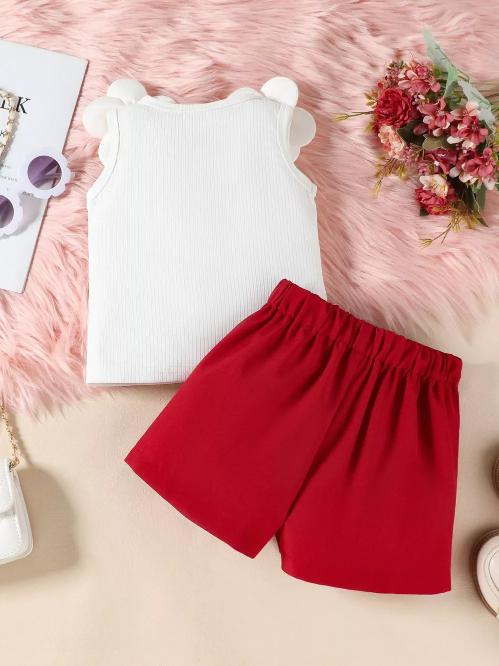Baby girl's white ribbed tank top with ruffled sleeves and red bow skort.