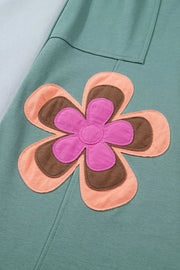 Green cotton sweatpants with a colorful floral applique detail.