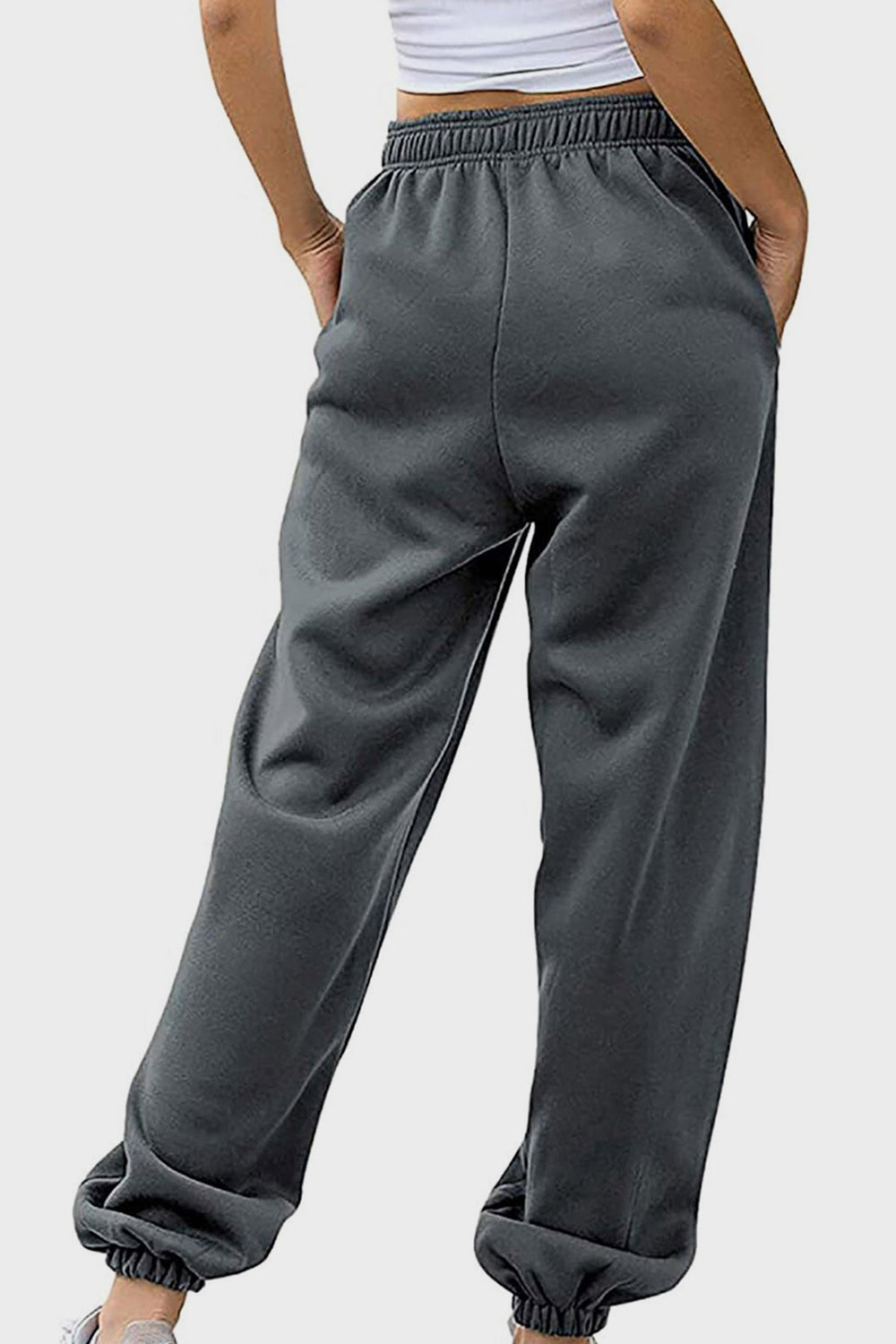 Relaxed-fit cuffed sweatpants in dark gray with an elastic waistband and pockets.
